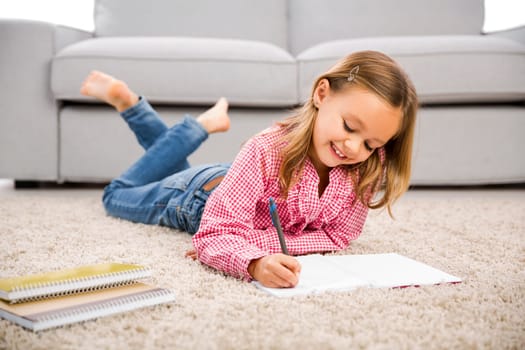 Cute little girl at home studying