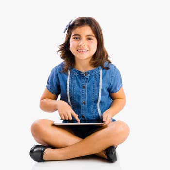 Young girl sitting on floor and using a tablet