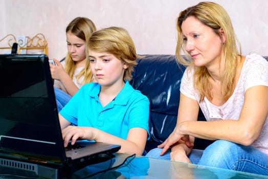 blond mother and her children using computer together
