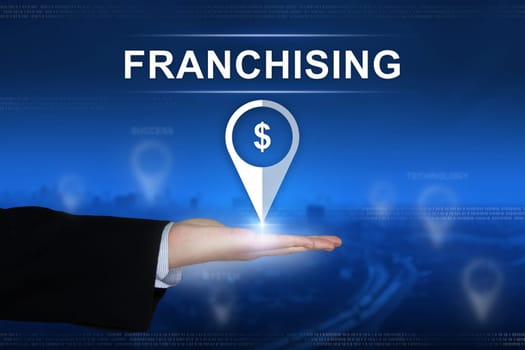 franchising button with business hand on blurred background