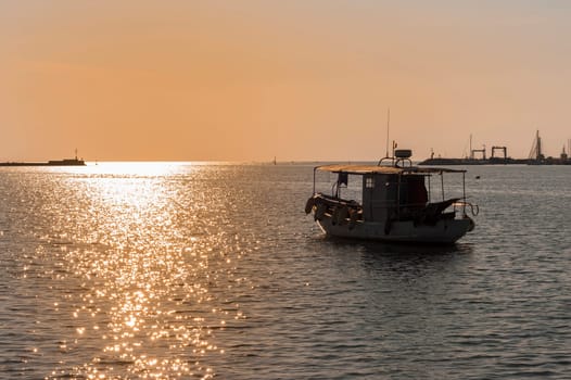 Professional fishing boat leaves the harbour at sunset