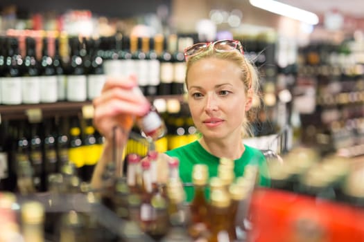 Beautiful caucasian woman shopping groceries at supermarket.