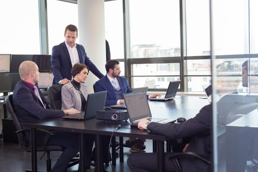 Workplace in modern office with business people brainstorming. Businessman working on laptop during the meeting.
