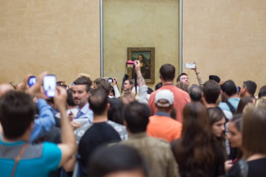 Paris, France - June 12: Crowd of visitors takes photos of Leonardo DaVinci&#39 s Mona Lisa, one of world&#39 s most famous work of art, at Louvre Museum on 12th of June ,2016 in Paris, France.