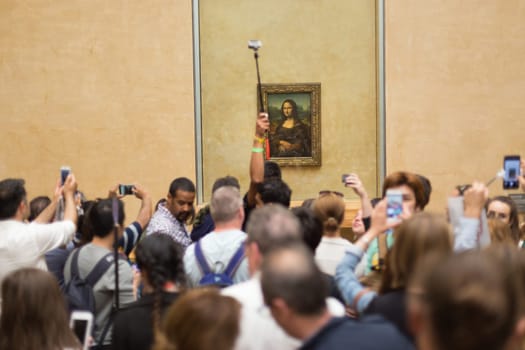Paris, France - June 12: Crowd of visitors takes photos of Leonardo DaVinci&#39 s Mona Lisa, one of world&#39 s most famous work of art, at Louvre Museum on 12th of June ,2016 in Paris, France.