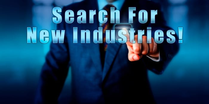 Industrial manager is pressing Search For New Industries! on an interactive touch screen. Business objective concept, call to action and motivational metaphor. Close up torso shot of man in blue suit.