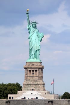 The Statue of Liberty (Liberty Enlightening the World), a colossal neoclassical sculpture on Liberty Island in the middle of New York Harbor, Manhattan. The statue is of a robed female figure representing Libertas, the Roman goddess of freedom, who bears a torch and a tabula ansata