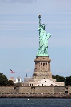 The Statue of Liberty (Liberty Enlightening the World), a colossal neoclassical sculpture on Liberty Island in the middle of New York Harbor, Manhattan. The statue is of a robed female figure representing Libertas, the Roman goddess of freedom, who bears a torch and a tabula ansata