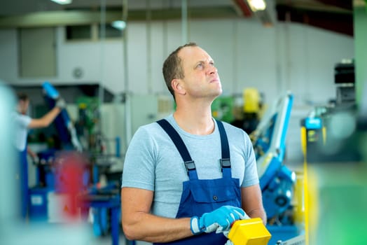 young worker in factory using machine