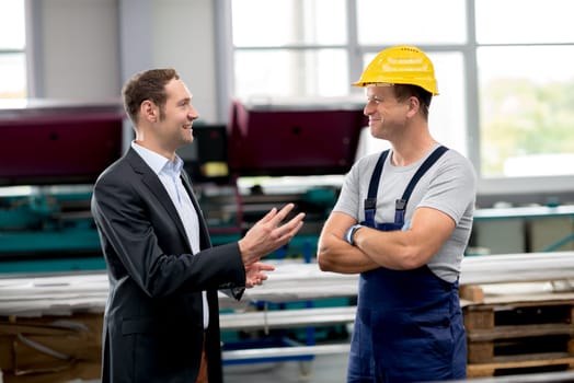 in the factory- young boss and worker in conversation