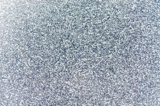 Shiny detailed surface of a gray stone slab with natural clay slope. Used as background or texture.