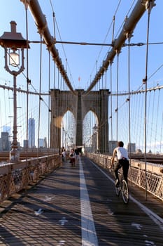 NEW YORK, SEPTEMBER 05: Pedestrians and tourists in Famous historic Brooklyn Bridge in Manhattan over Hudson River in September 05, 2013 in New York.