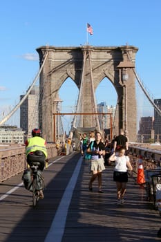 NEW YORK, SEPTEMBER 05: Pedestrians and tourists in Famous historic Brooklyn Bridge in Manhattan over Hudson River in September 05, 2013 in New York.