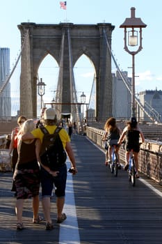 NEW YORK, SEPTEMBER 05: Pedestrians and tourists in Famous historic Brooklyn Bridge in Manhattan over Hudson River in September 05, 2013 in New York.