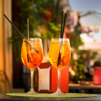 Aperol Spritz Cocktail. Alcoholic beverage based on table with ice cubes and oranges.