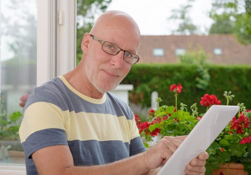 a portrait of a mature man with a tablet