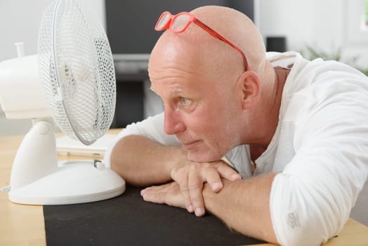 a mature man refreshed with a fan