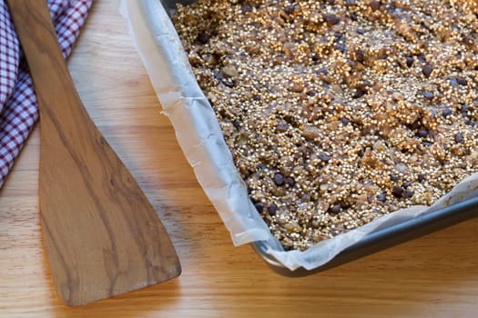 Quinoa baking bars in baking pan and spatula.
