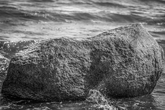 Boulder in the surf - Baltic Sea beach - in a detail shot - black and white converted