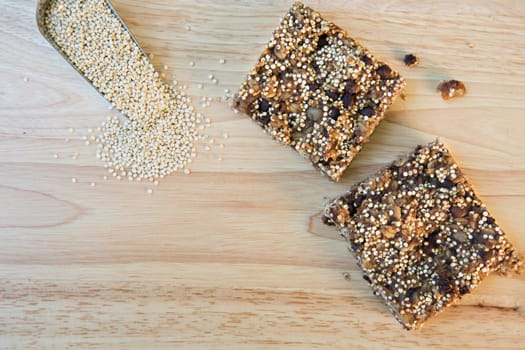 Two quinoa breakfast squares with scoop of raw quinoa and copy space.