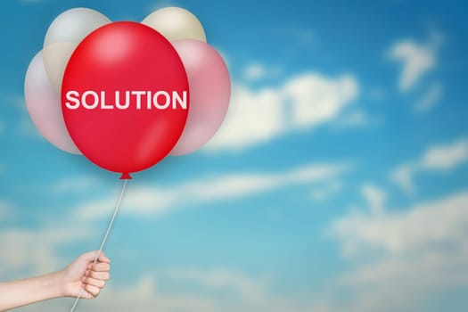 Hand Holding solution Balloon with sky blurred background