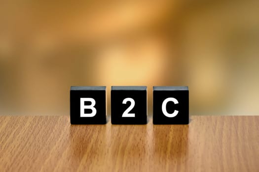 B2C or Business to consumer on black block with blurred background