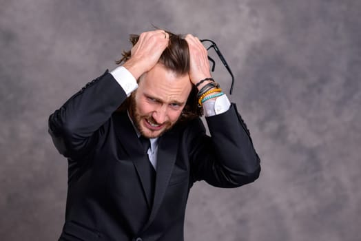 portrait of a young stressed business man in black suit