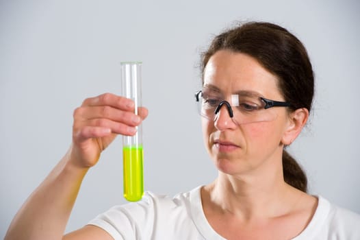 dark haired female lab assistand with test tube