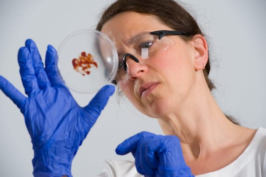 dark haired female lab assistand with Petri dish