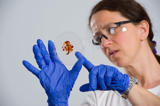 dark haired female lab assistand with Petri dish
