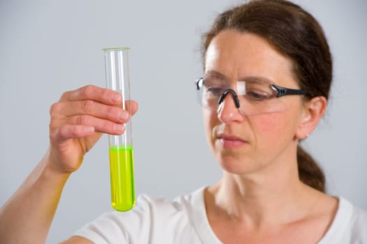 dark haired female lab assistand with test tube