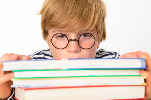 tired blond boy on a pile of books