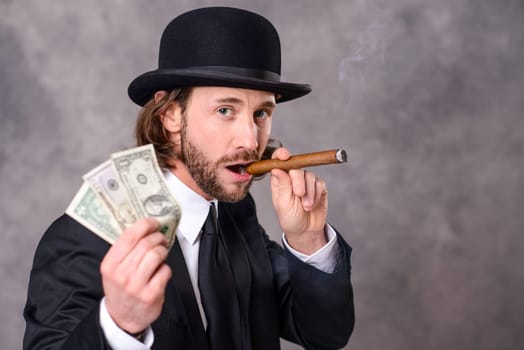 young businessman with bowler hat and big cigar and money