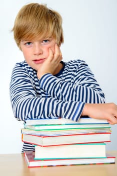 blond boy on a pile of books