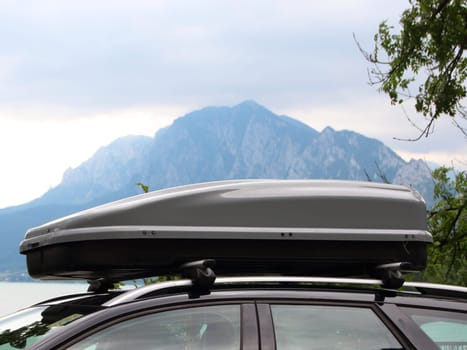Car Rooftop Box with Cloudy Mountain and Lake in Background Horizontal
