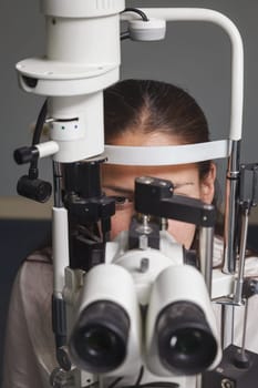 Beautiful young woman having eye test at the optometrist