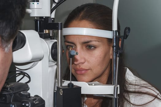 Beautiful young woman having eye test at the optometrist.