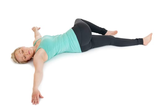 Woman lying on her back with her pelvis twisted to the side and her upper leg overturned. Arms outstretched laterally.