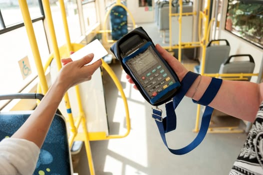 Human hand holding plastic cards. Passenger pays for the fare in public transport. Payment terminal, credit card reader, sales concept.