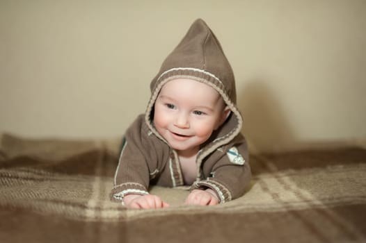 Cute baby playing on the bed, smiling and posing to the camera