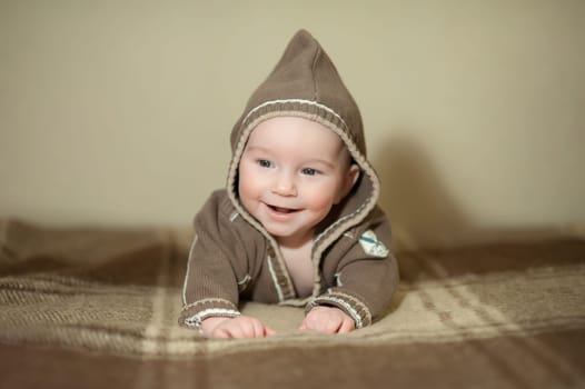 Cute baby playing on the bed, smiling and posing to the camera