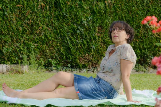 a mature woman is resting in the garden