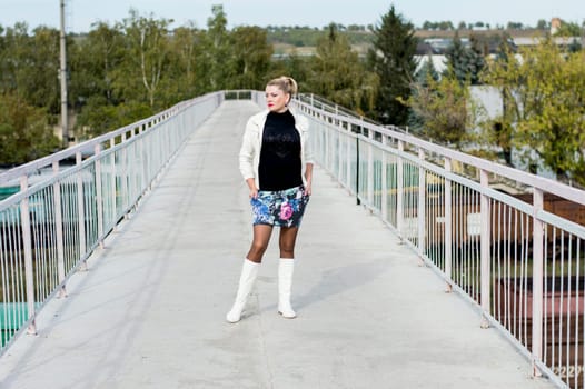 the sexy woman in a white jacket and white boots on the bridge, a subject beautiful women and railway roads