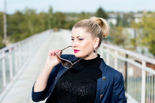 portrait of the beautiful woman on the bridge removing sunglasses, a subject beautiful women and railway roads