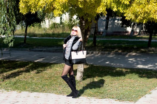the beautiful woman with a bag goes in the fall on the cities, a subject seasons and beautiful women are more scarlet fall