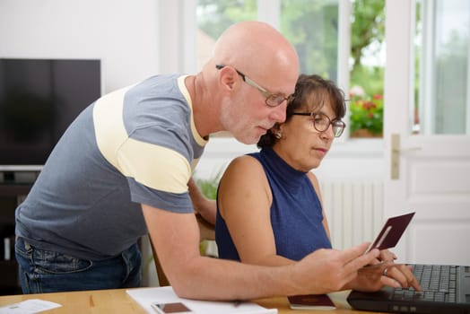 a senior couple prepare the holidays on the internet