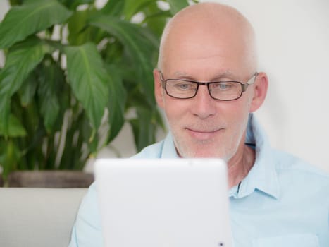 a mature man at home websurfing on internet
