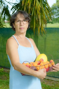 a mature woman with a blue dress and a fruit basket