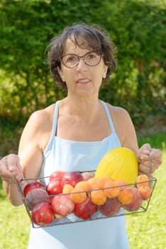 a mature woman with a blue dress and a fruit basket