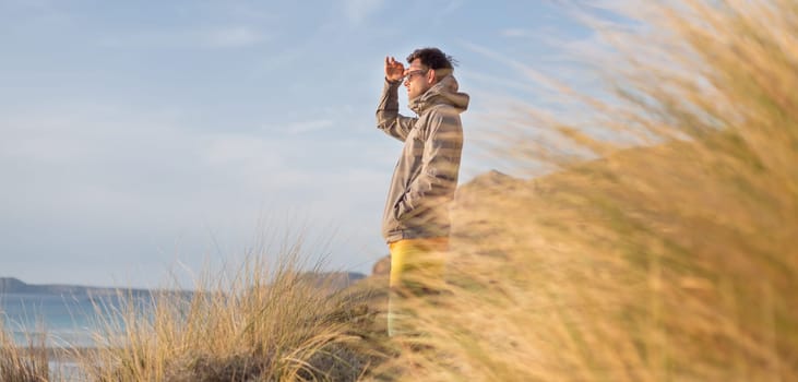 Sporty active man looking at distance, enjoying beautiful nature, freedom and life at serene landscape at Balos beach. Active lifestyle outdoors.